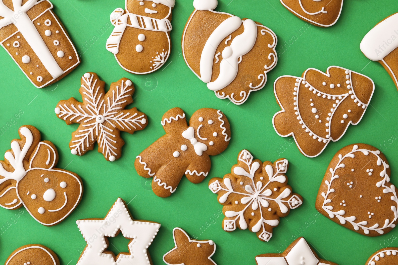 Photo of Different Christmas gingerbread cookies on green background, flat lay