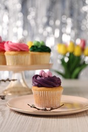 Photo of Tasty Easter cupcakes on wooden table, selective focus