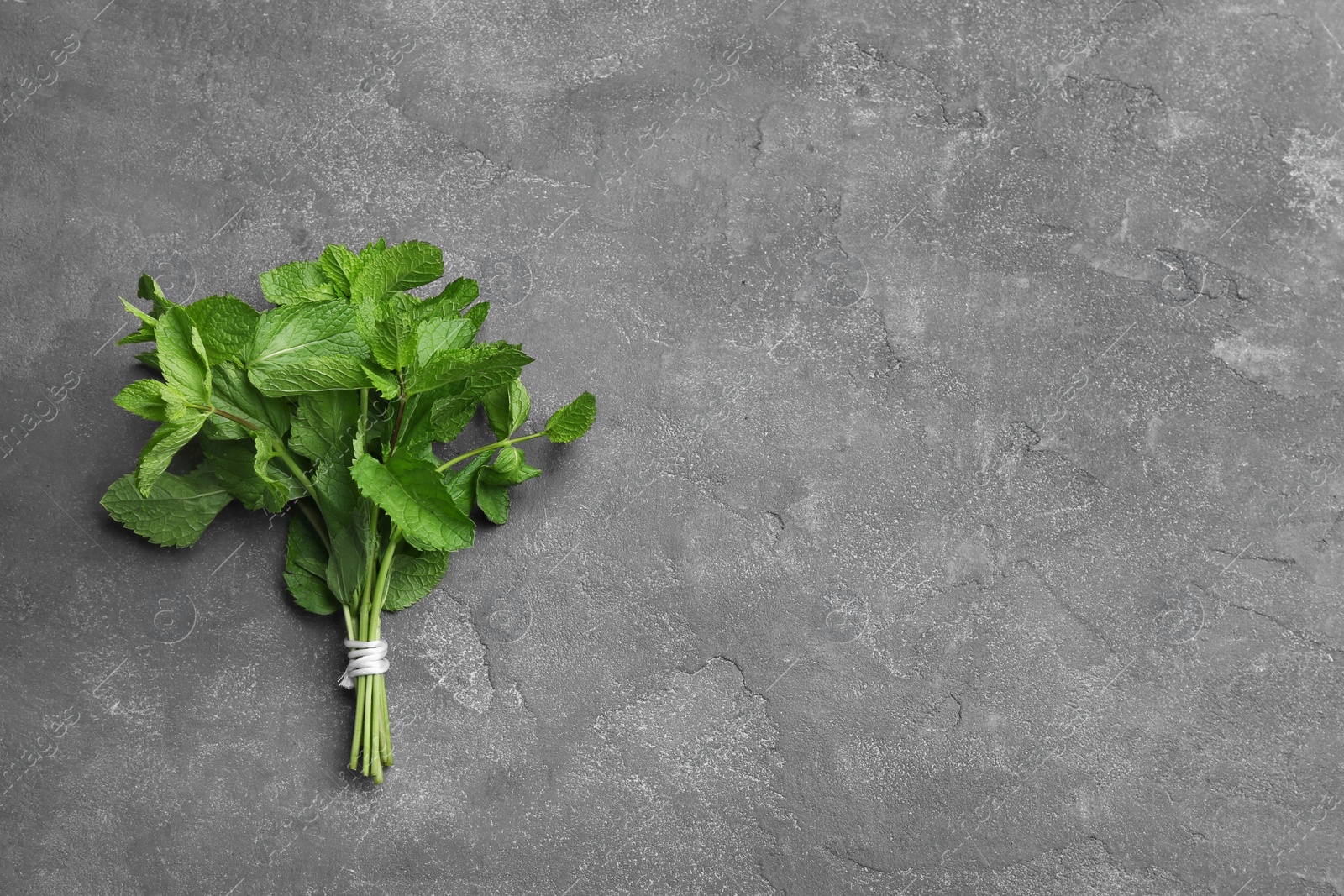 Photo of Bunch of fresh mint on grey background, top view. Space for text