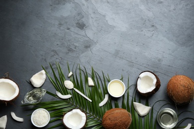 Photo of Flat lay composition with natural organic oil and coconuts on grey stone background. Space for text