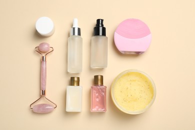 Photo of Flat lay composition with skin care products and face roller on beige background