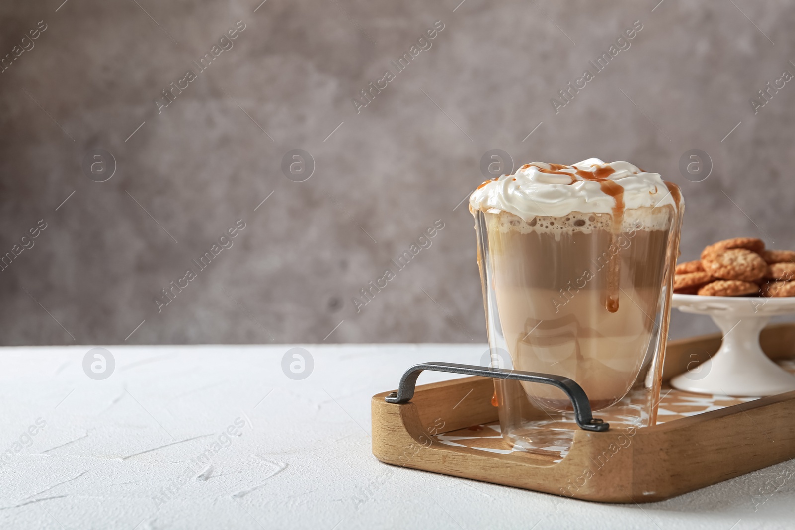 Photo of Glass of tasty caramel macchiato on table, Space for text