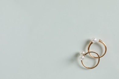 Elegant golden rings with pearls on white table, flat lay. Space for