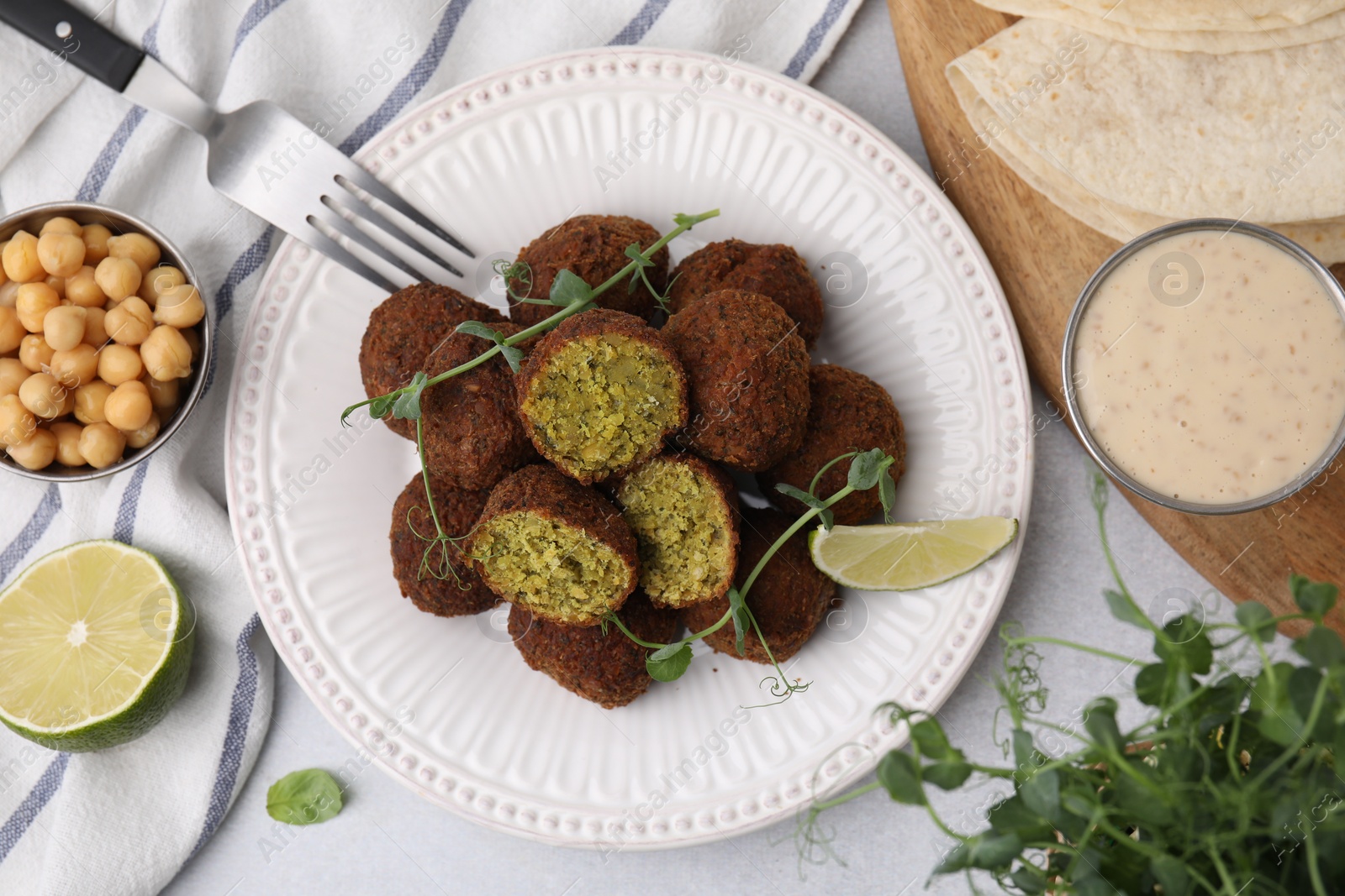 Photo of Delicious falafel balls served on light table, flat lay