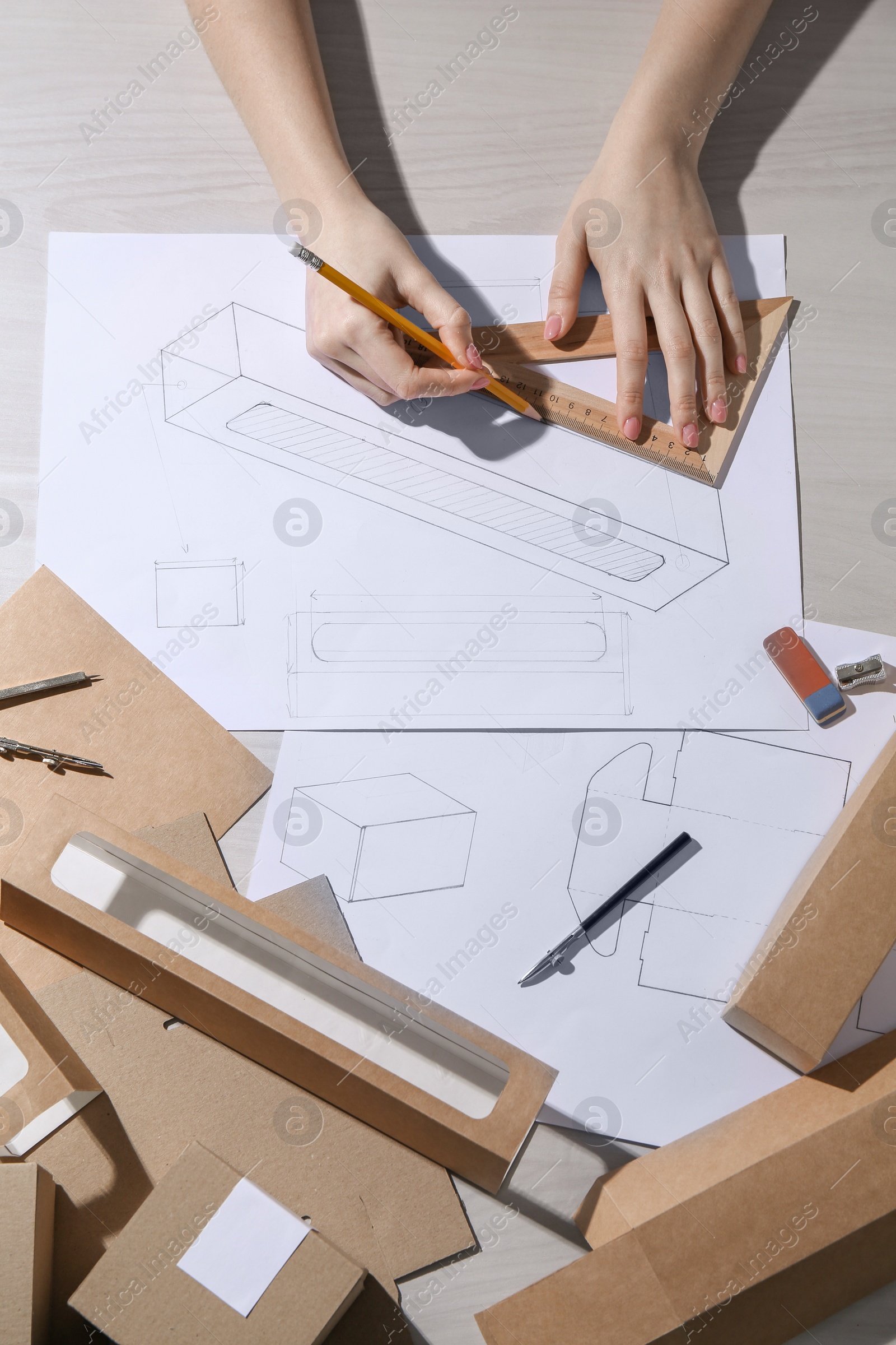 Photo of Woman creating packaging design at light wooden table, top view