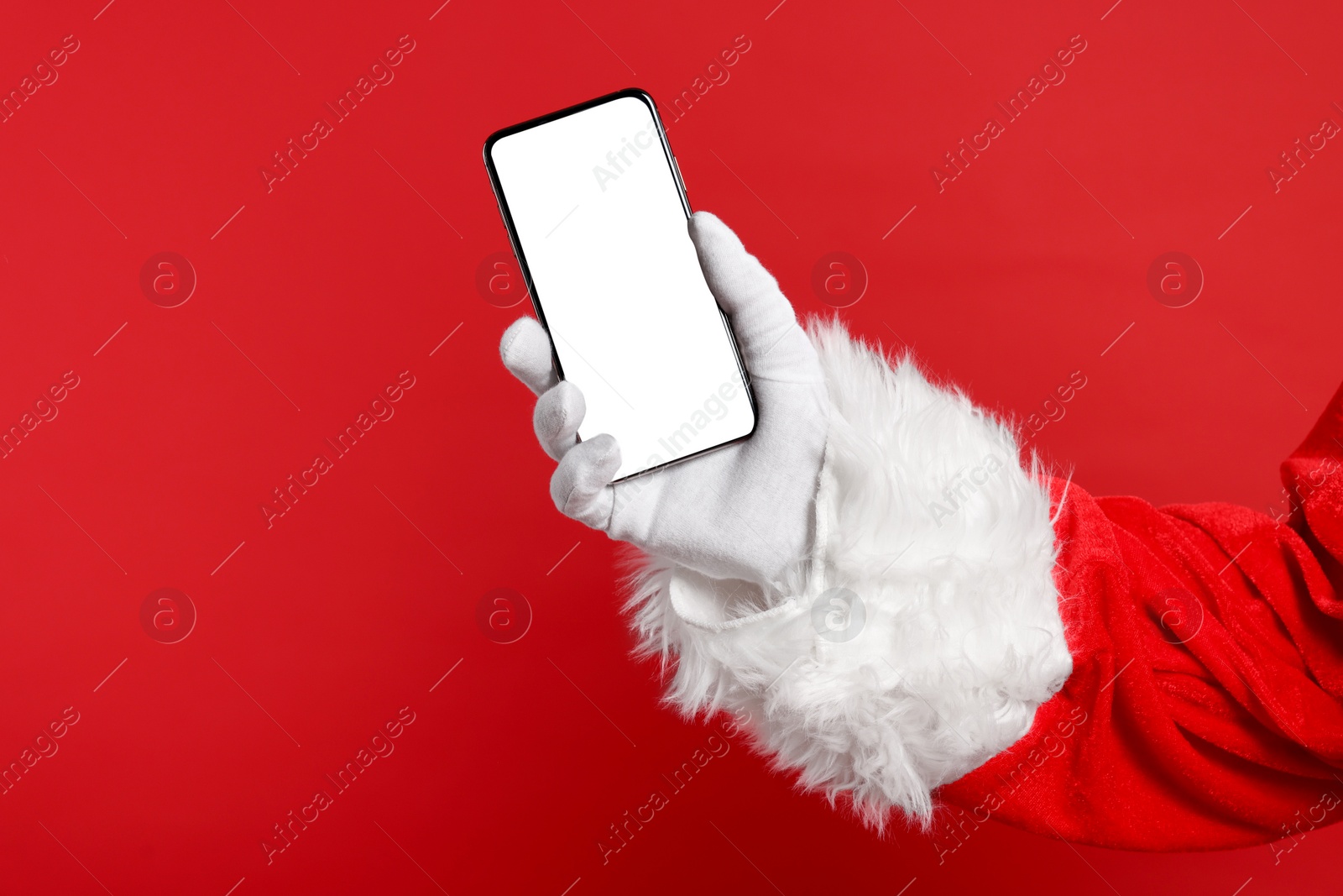 Photo of Merry Christmas. Santa Claus showing smartphone on red background, closeup. Mockup for design