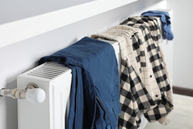 Photo of Clothes hanging on white radiator in room