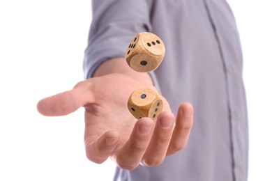 Man throwing wooden dice on white background, closeup