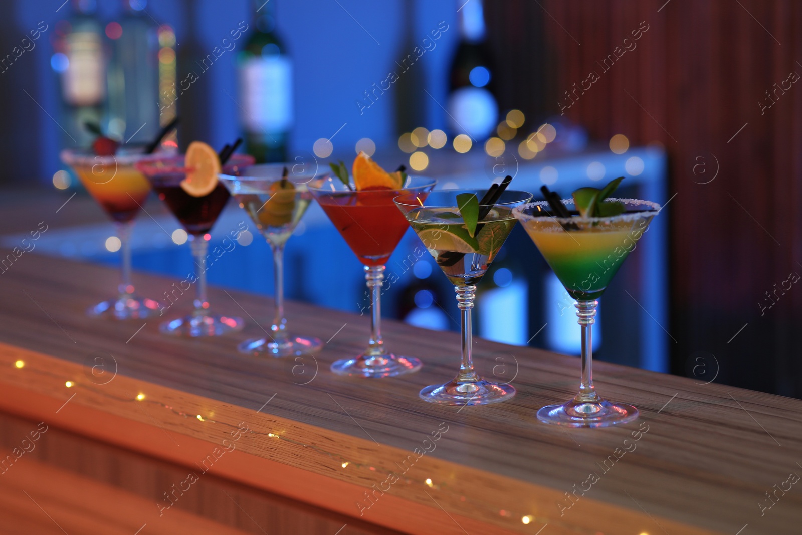 Photo of Different martini cocktails on table in bar