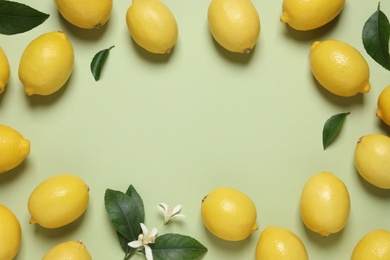 Frame of fresh ripe lemons on light green background, flat lay. Space for text