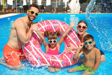 Photo of Happy family having fun in swimming pool