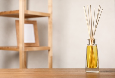 Reed air freshener on wooden table indoors, space for text