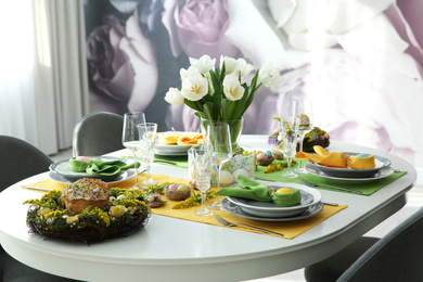 Festive Easter table setting with beautiful white tulips and eggs indoors