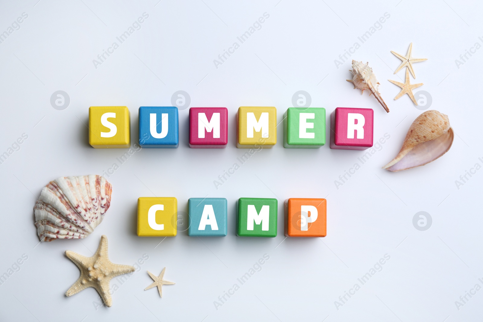 Photo of Colorful wooden cubes with phrase SUMMER CAMP on white background, flat lay