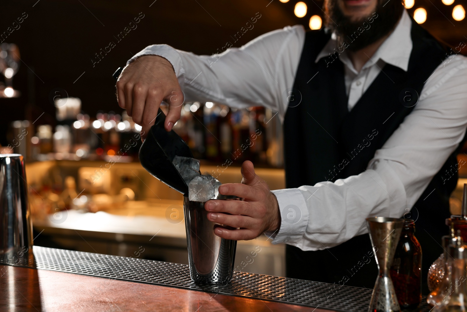 Photo of Bartender making fresh alcoholic cocktail at bar counter, closeup