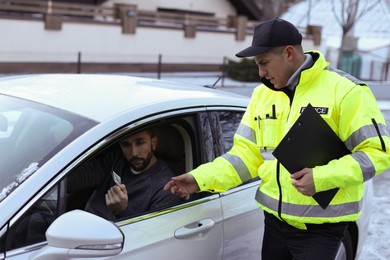 Man giving bribe to police officer out of car window outdoors