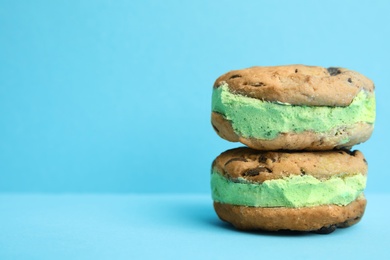 Photo of Sweet delicious ice cream cookie sandwiches on color background, space for text