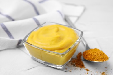 Photo of Tasty curry sauce and powder on white table, closeup