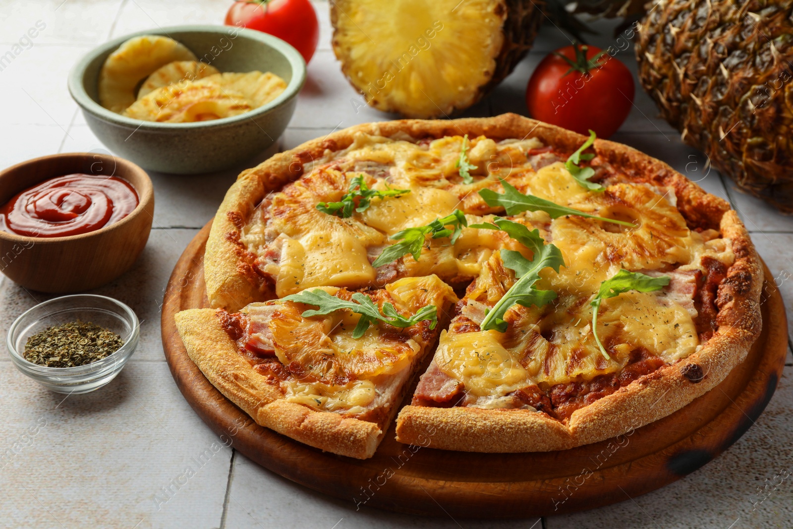 Photo of Delicious cut pineapple pizza on light gray table, closeup