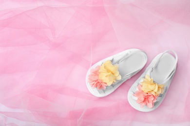 Photo of Pair of cute baby sandals on color fabric, top view