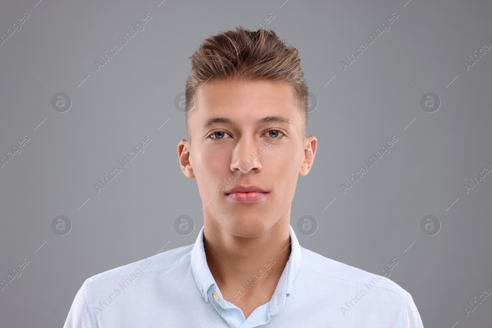 Photo of Portrait of handsome young man on grey background