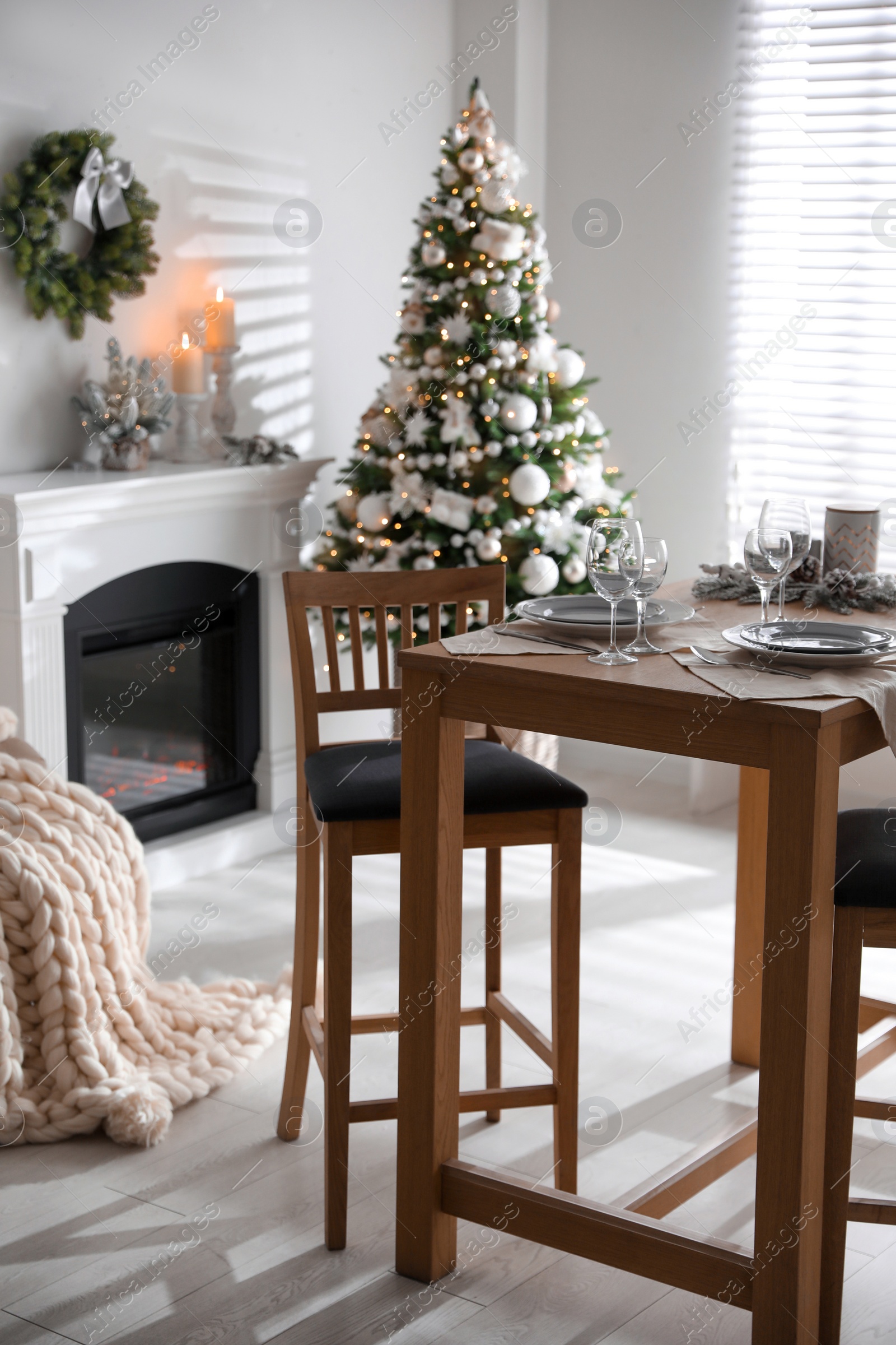 Photo of Festive table setting and beautiful Christmas decor in living room. Interior design