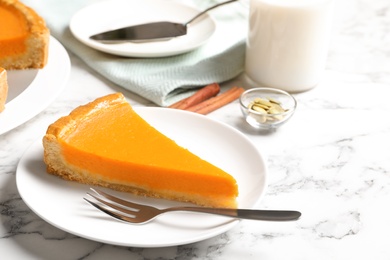 Photo of Plate with piece of fresh delicious homemade pumpkin pie on marble table
