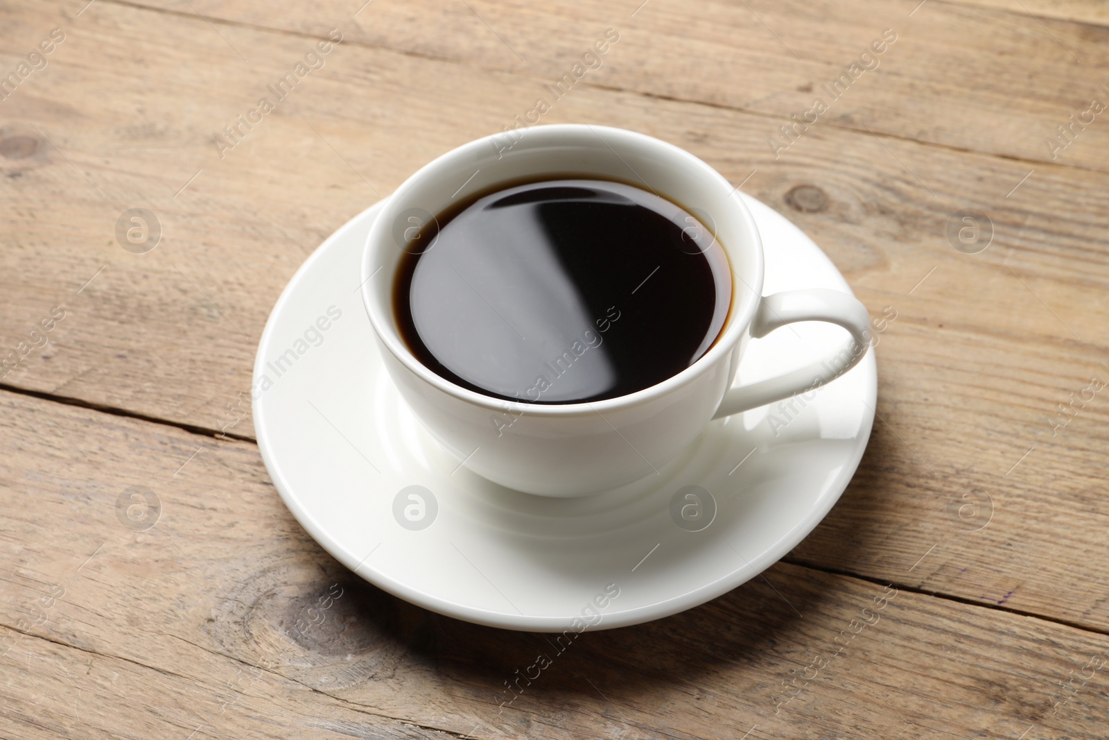 Photo of Cup of aromatic coffee on wooden table