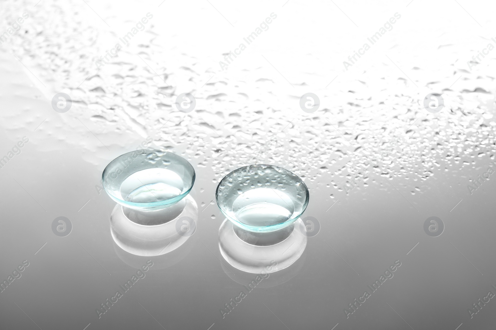 Photo of Contact lenses on wet glass background