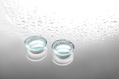 Contact lenses on wet glass background