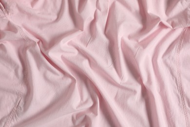 Photo of Crumpled pink fabric as background, top view