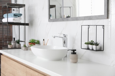 Photo of Bathroom counter with stylish vessel sink and houseplants. Interior design