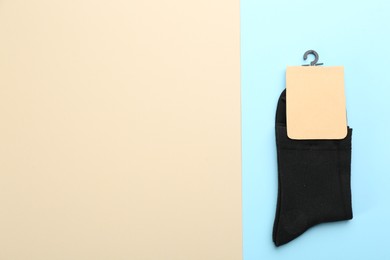 Photo of Pair of black cotton socks on color background, top view. Space for text