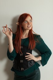 Photo of Beautiful redhead elf girl on light background
