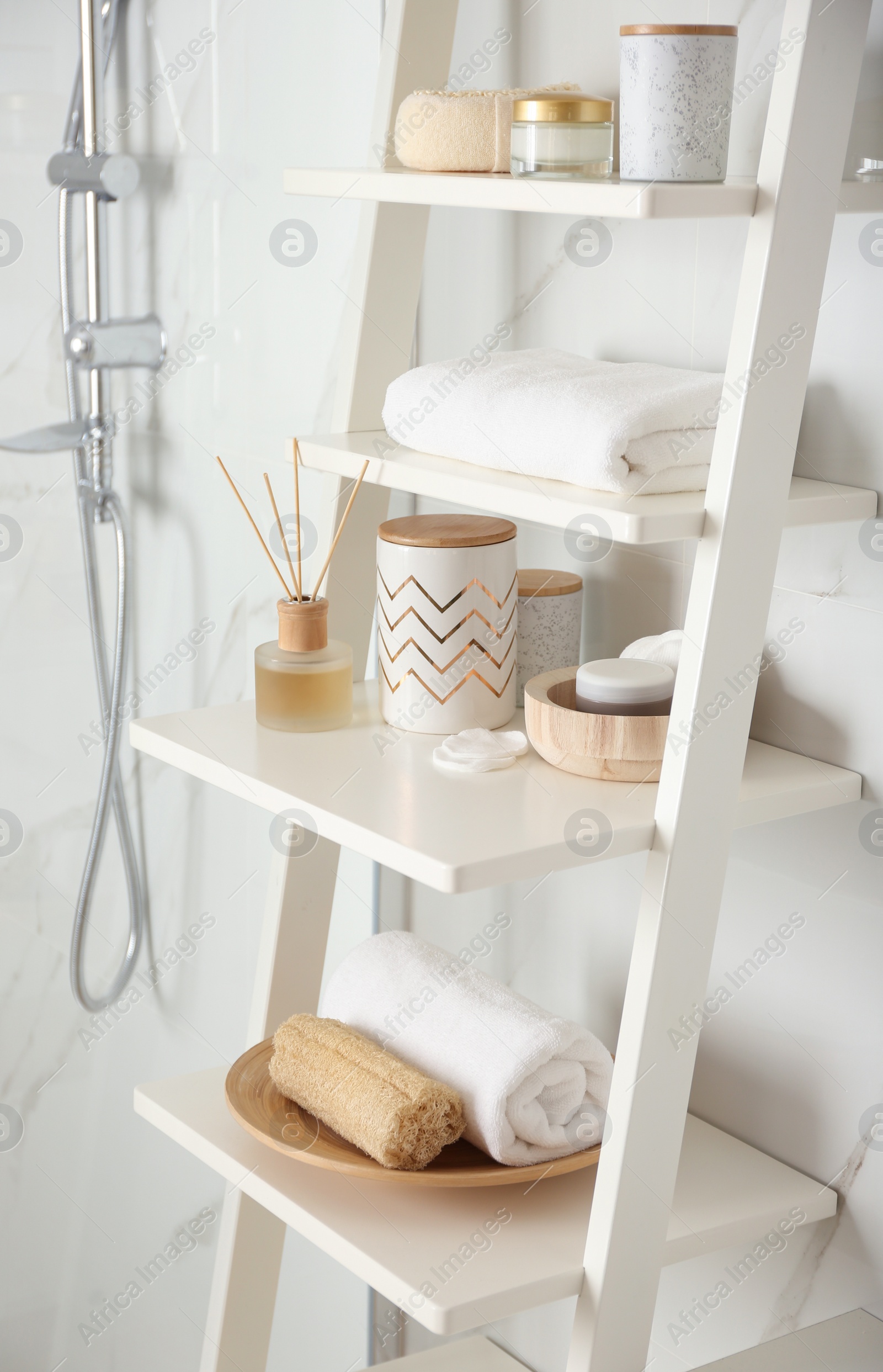 Photo of Shelving unit with different items in bathroom interior