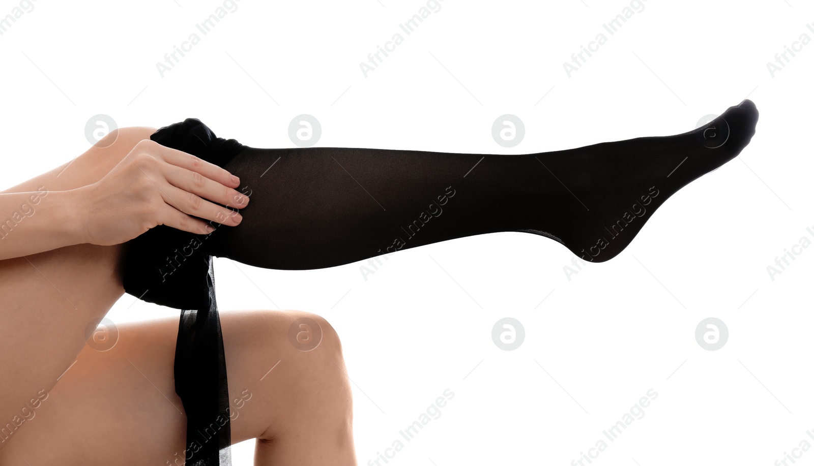 Photo of Young woman putting on tights against white background, closeup