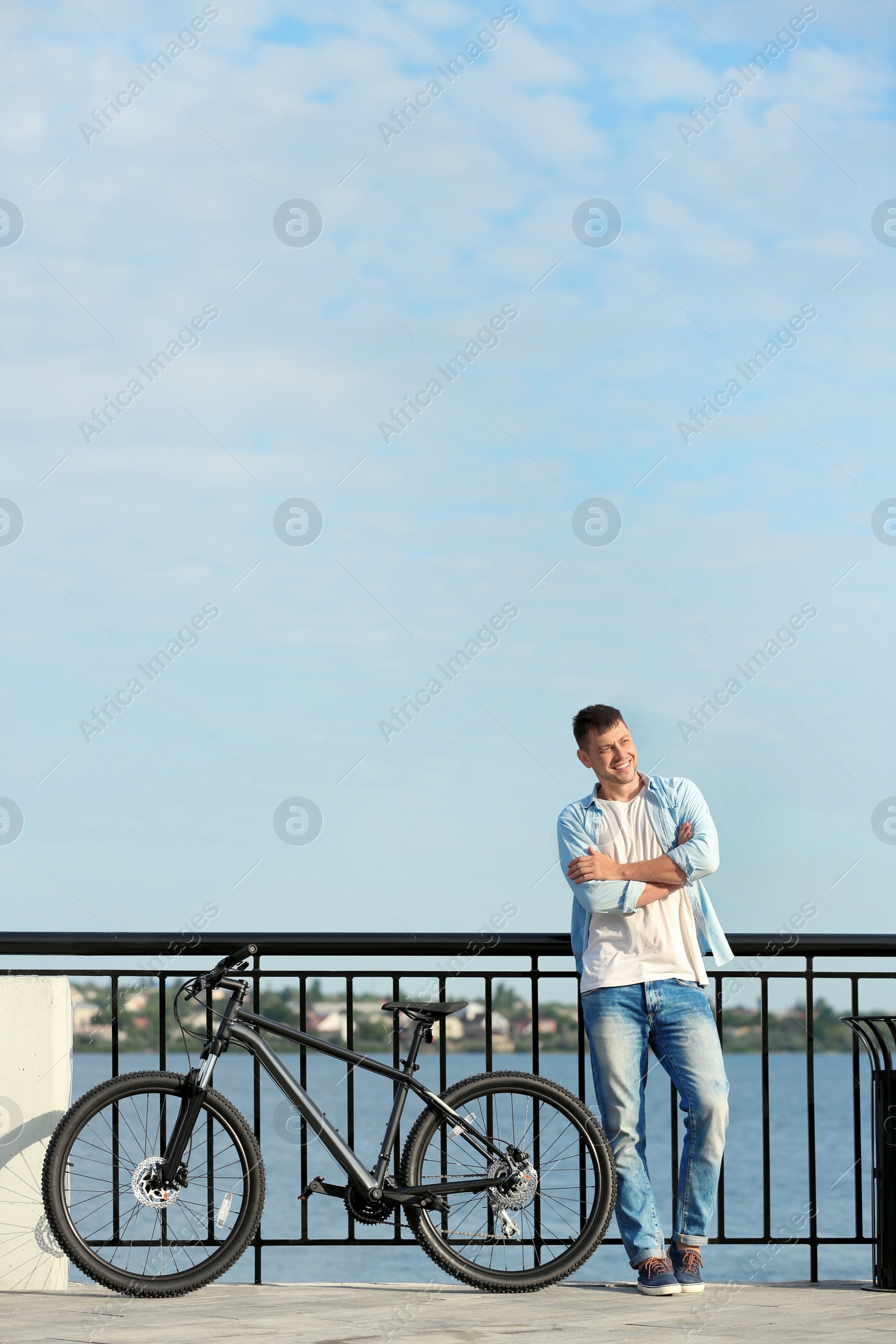 Photo of Handsome man with modern bicycle near river