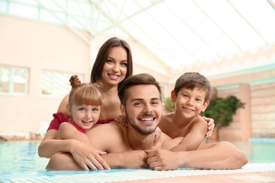 Photo of Happy family resting in indoor swimming pool