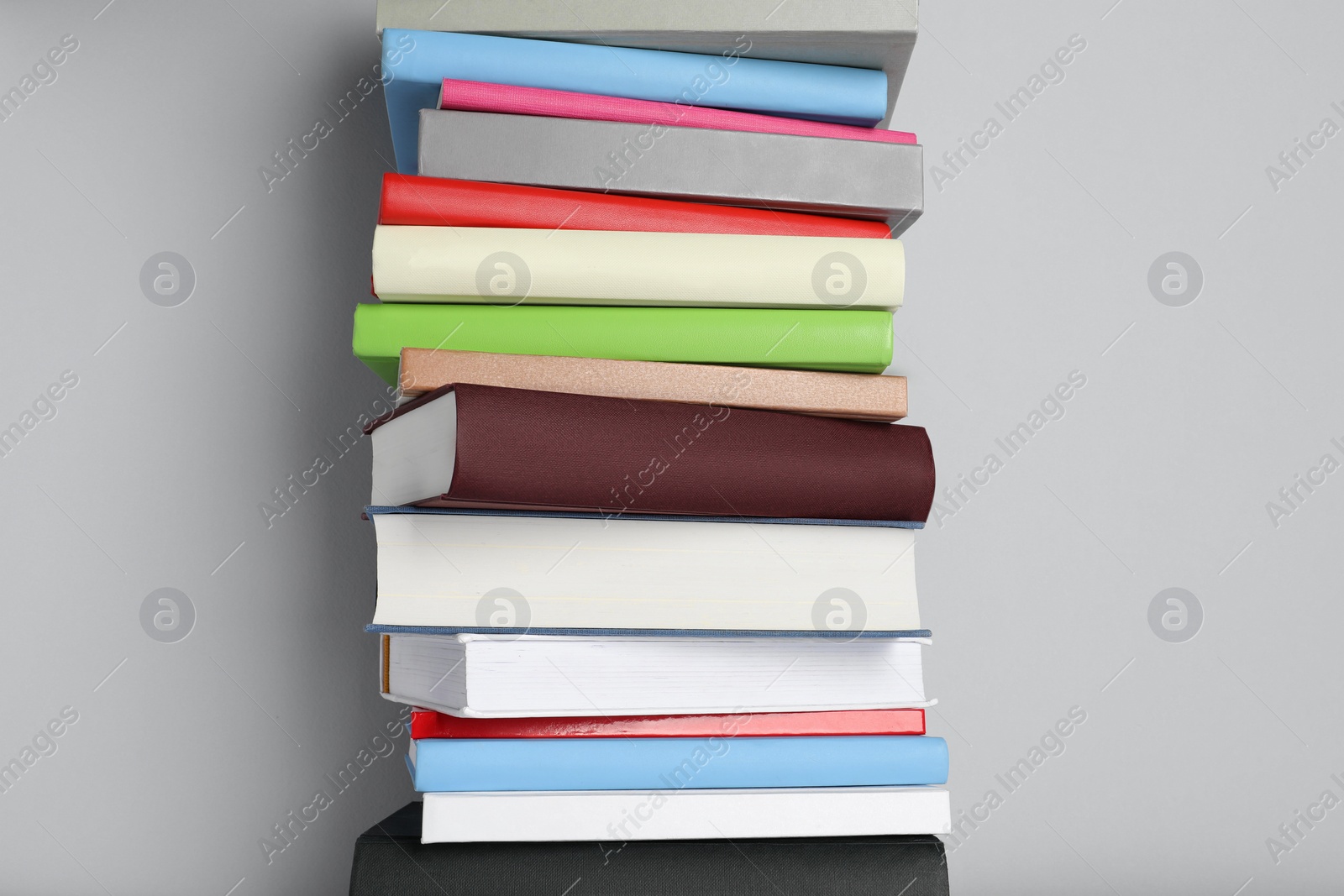 Photo of Stack of different books on light gray background