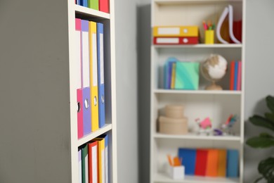Photo of Colorful binder office folders on shelving unit indoors