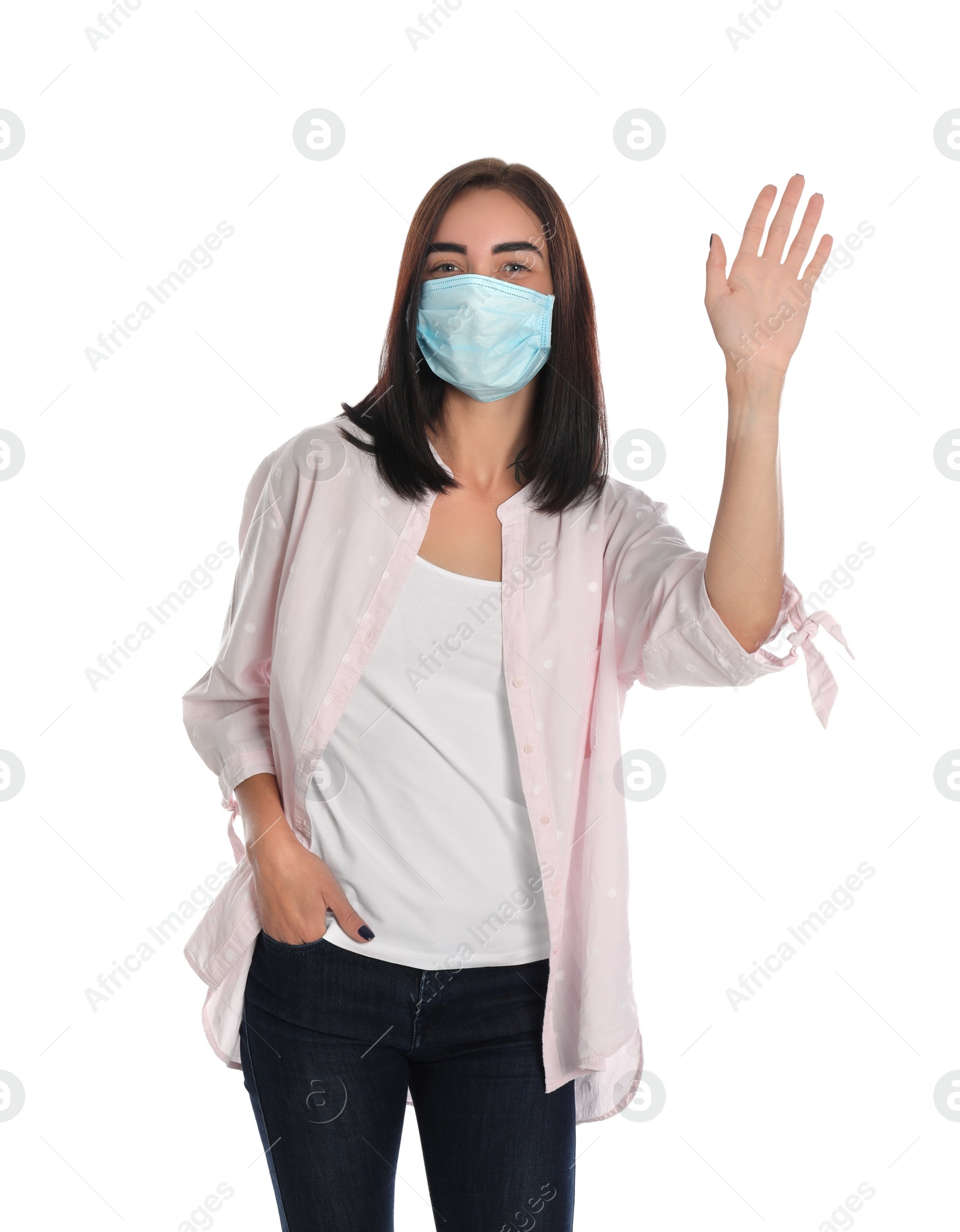 Photo of Young woman in protective mask showing hello gesture on white background. Keeping social distance during coronavirus pandemic