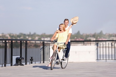 Photo of Happy couple riding bicycle outdoors on sunny day