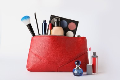 Photo of Cosmetic bag and makeup products with accessories on white background