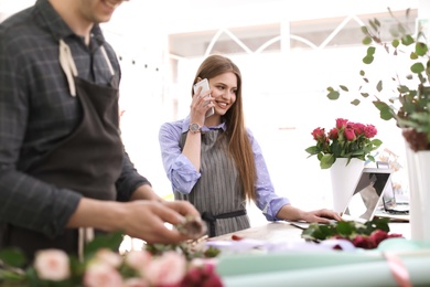 Male and female florists working in flower shop