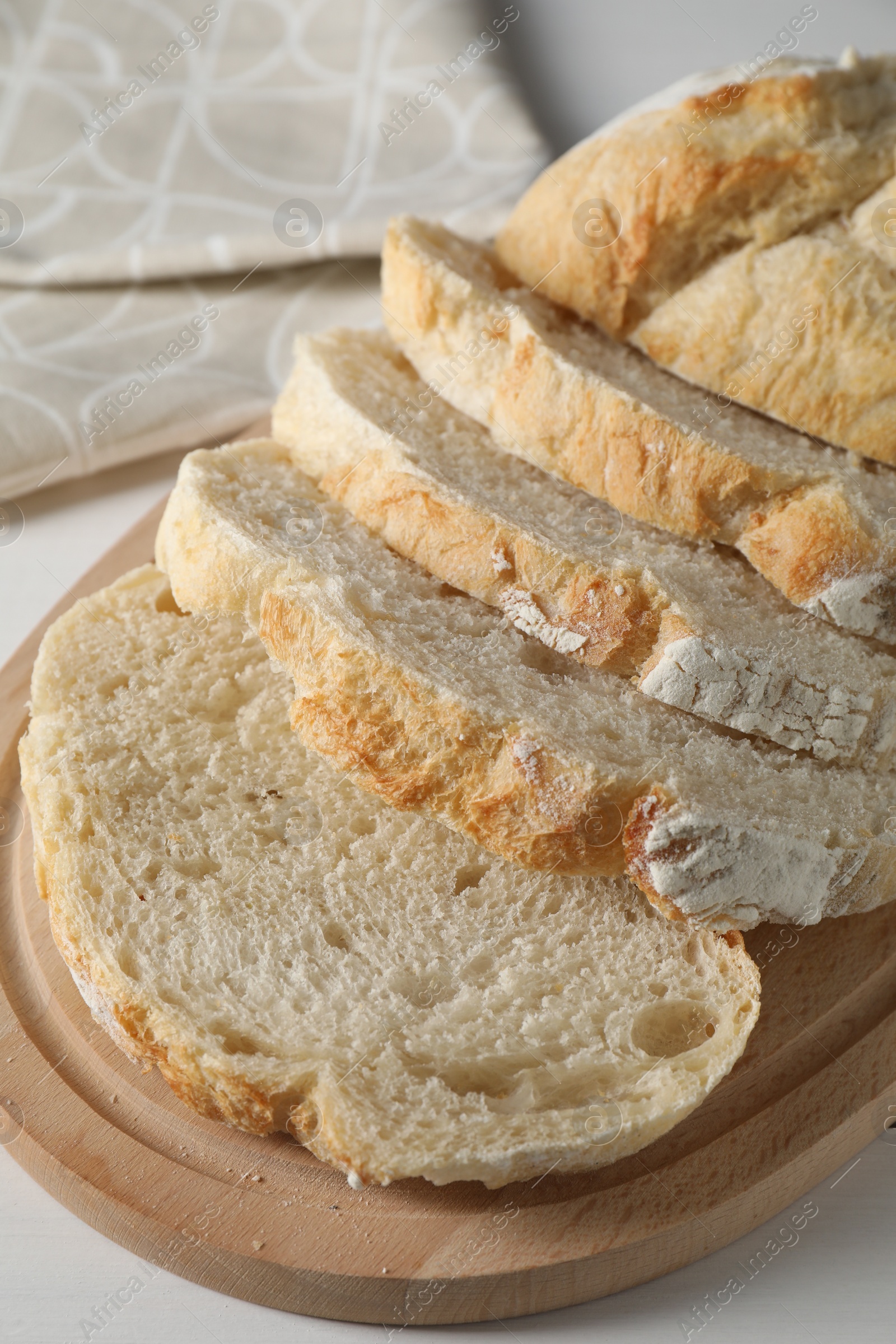 Photo of Freshly baked cut sourdough bread on white wooden table