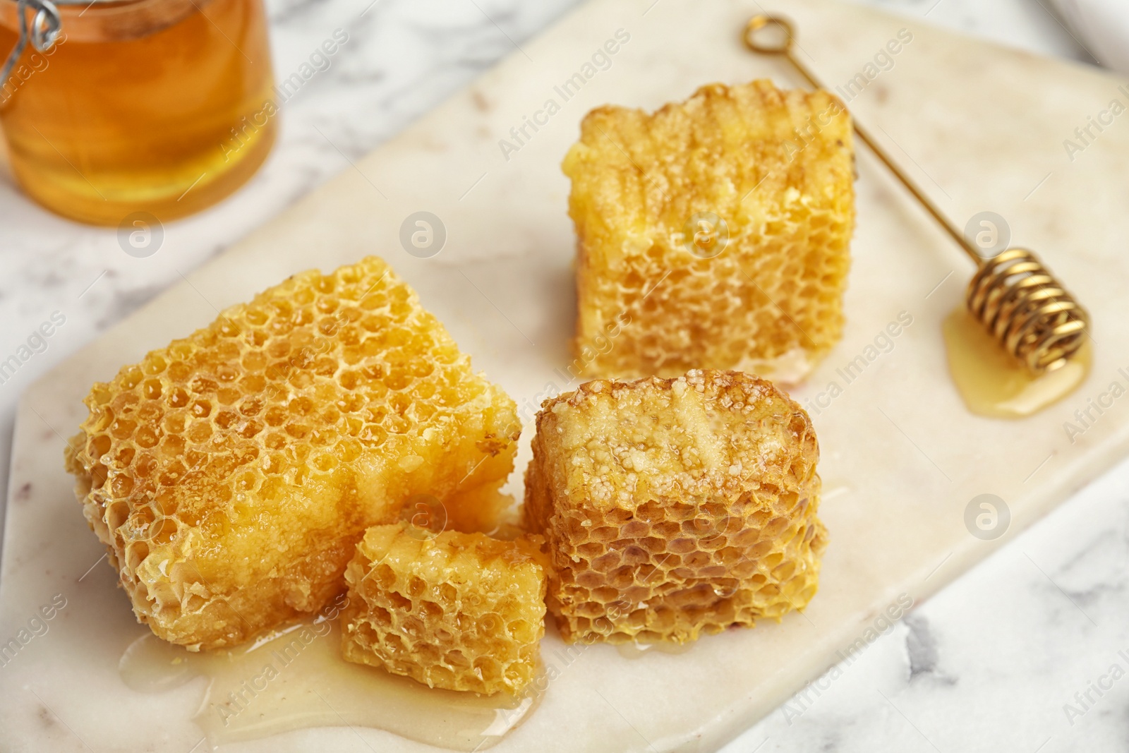 Photo of Fresh delicious sweet honeycombs on white board