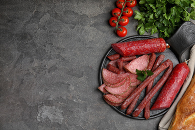 Photo of Different tasty sausages on grey table, flat lay. Space for text
