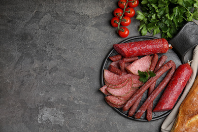 Different tasty sausages on grey table, flat lay. Space for text