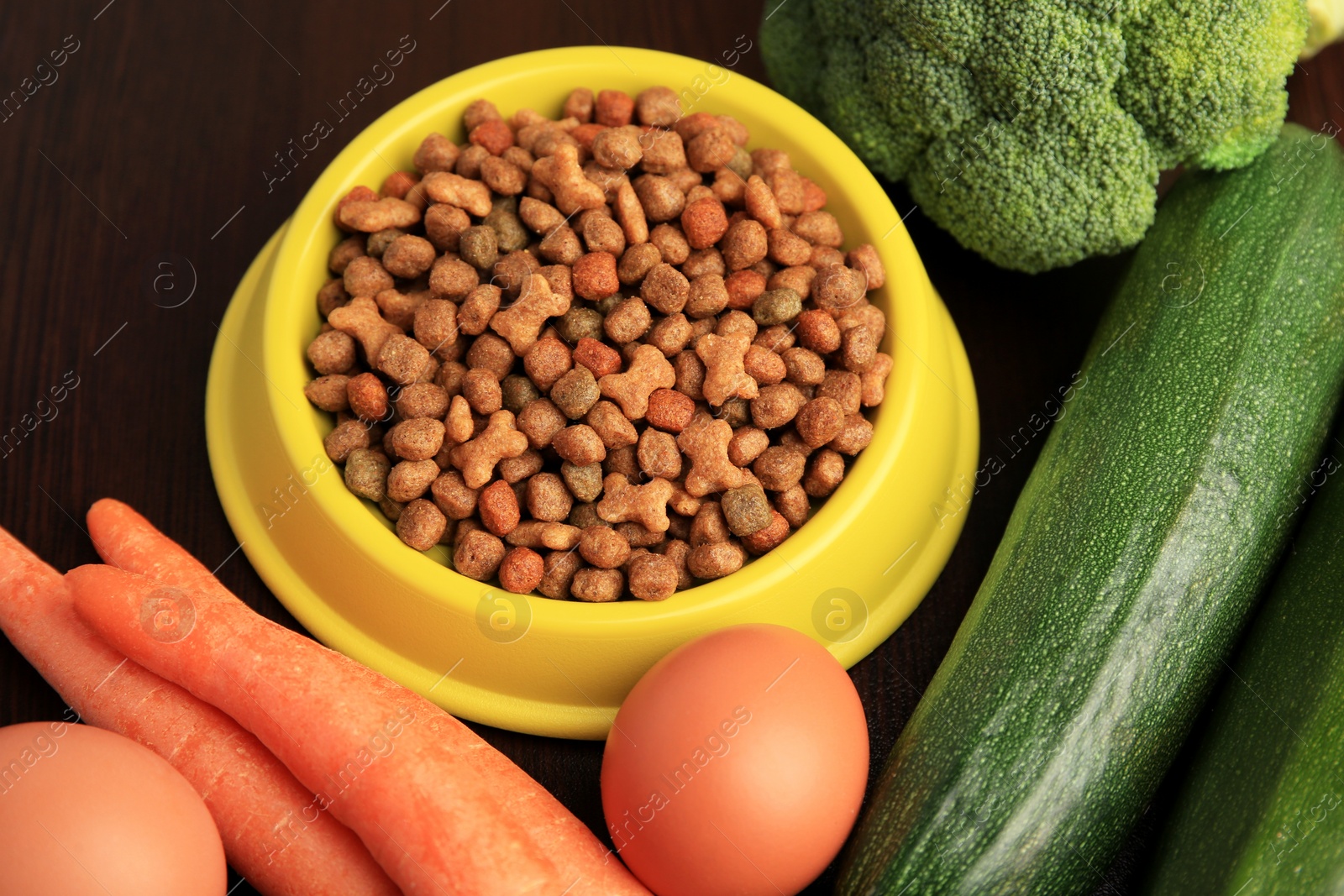 Photo of Dry pet food and products on wooden background