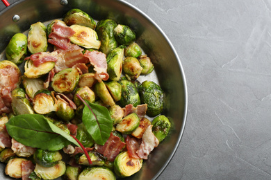 Photo of Delicious roasted Brussels sprouts with bacon on black table, top view